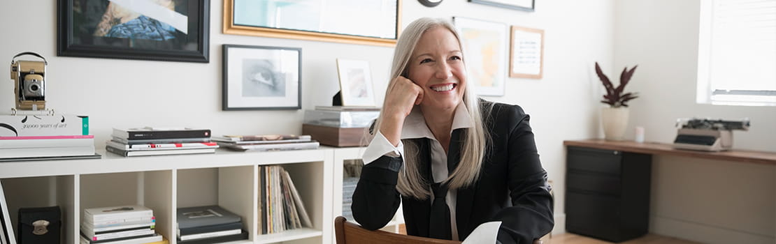 Woman sitting in front of framed photos hanging on wall